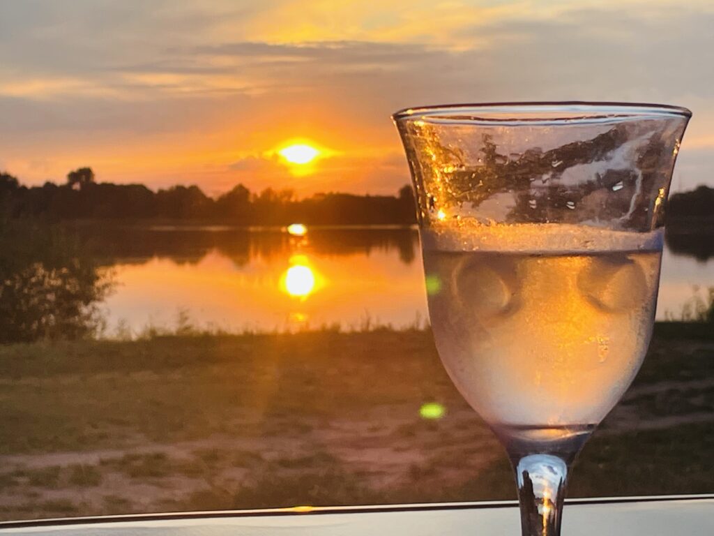 Ein Glas Wein am Rhein bei Sonnenuntergang